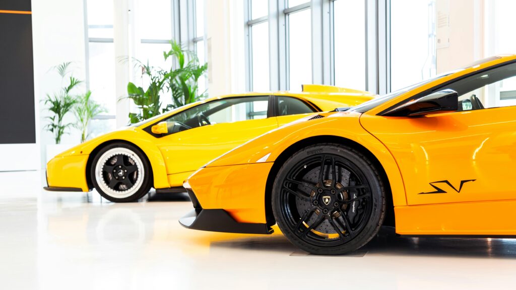 Bright yellow sports cars showcased in an elegant indoor showroom with natural lighting.