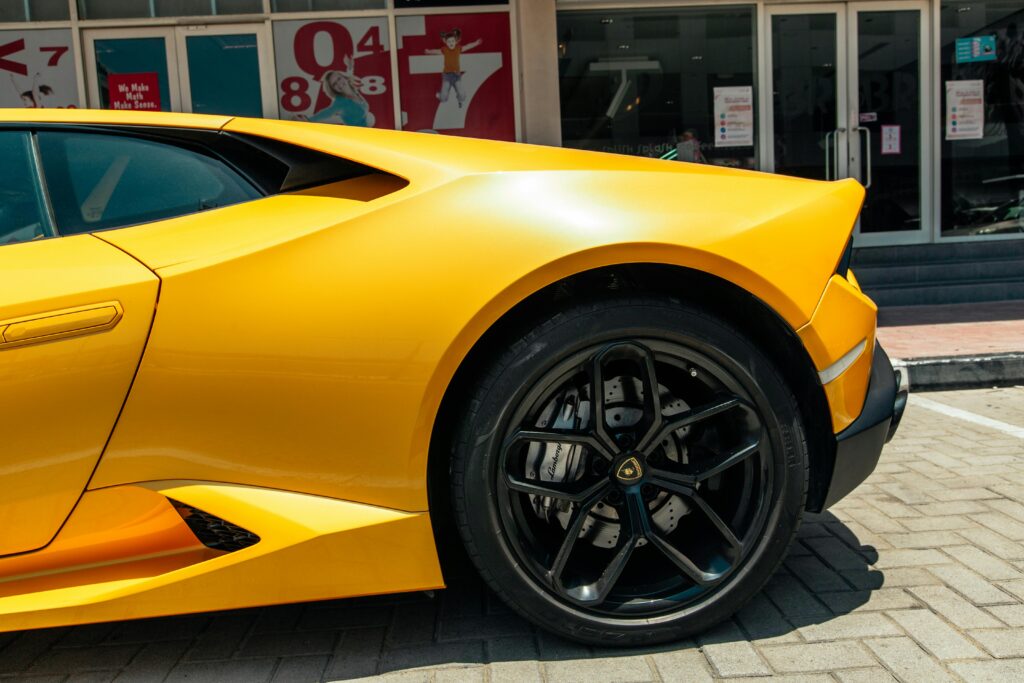 Close-up of a parked yellow sports car showcasing sleek design and modern wheels.